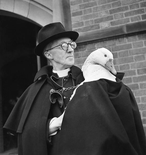 Monsignor Dunne and his pet goose Victor outside the church