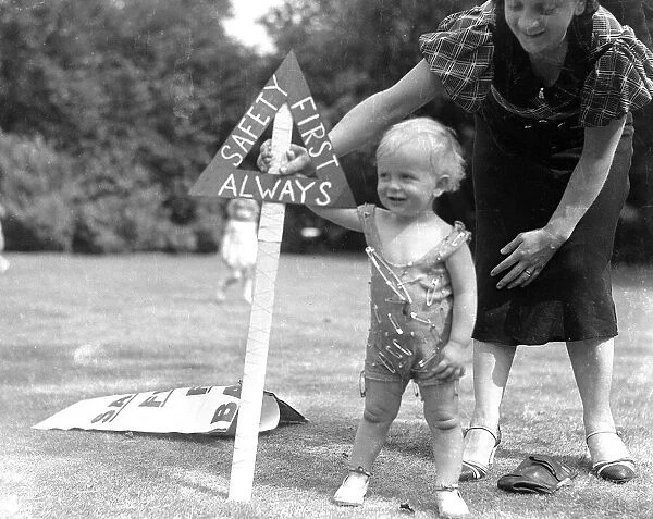 Mother and child covered in safety pins. 1st June 1935