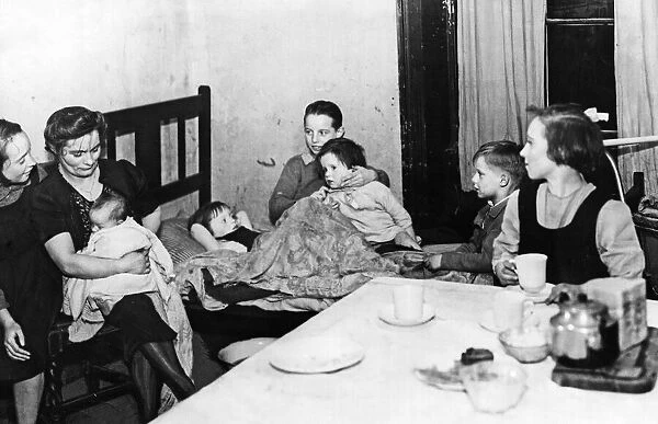 A mother and her family seen here living in one room of a Liverpool Terrace slum