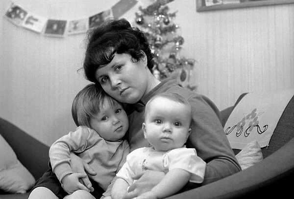 Mother holding her baby boy and todder. December 1969 Z12413