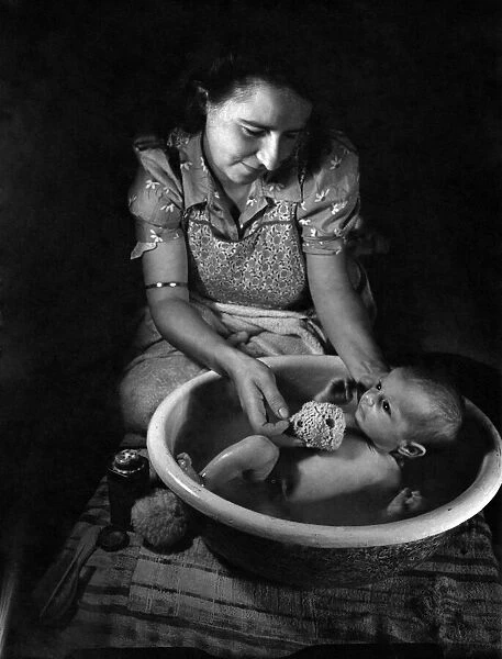 Mother Janet Trayler washing her 4 weeks old baby. August 1943 P009458