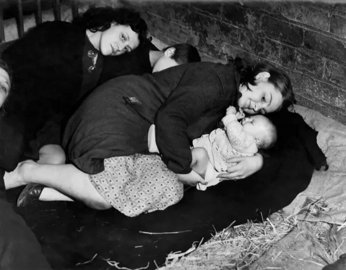 Framed Print : A Mother protects her baby whilst taking cover from air raid in a farmers barn