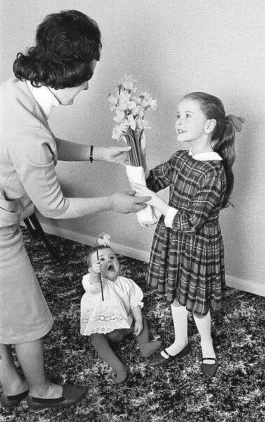 Mothers Day, child giving flowers to mother 5th March 1964