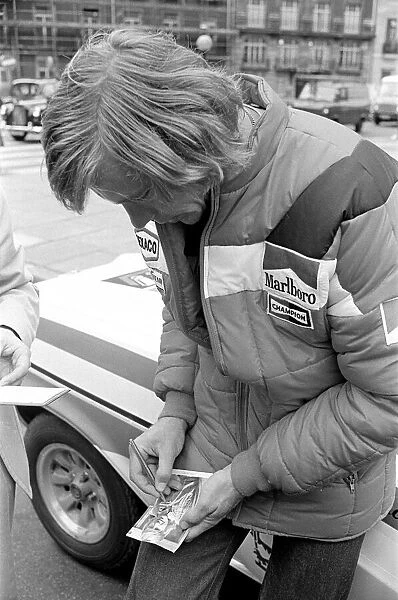 Motor Racing Driver James Hunt signs his autograph on a photograph of himself