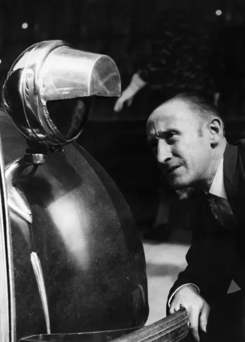 Framed Print : Motorist seen here inspecting a newly installed blackout hood on the headlights of his Framed Print : Motorist seen here inspecting a newly installed blackout hood on the headlights of his