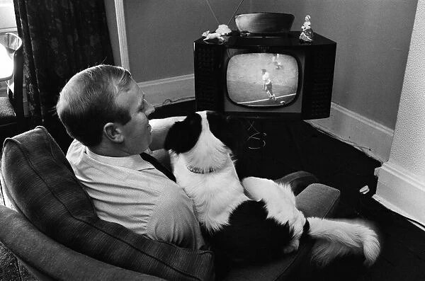 Mr David Corbett and Pickles the dog watching the World Cup Final on a television screen