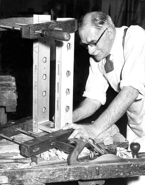Mr. George Wilson, aged 75, is working on the draw stop action of an organ at Horrison