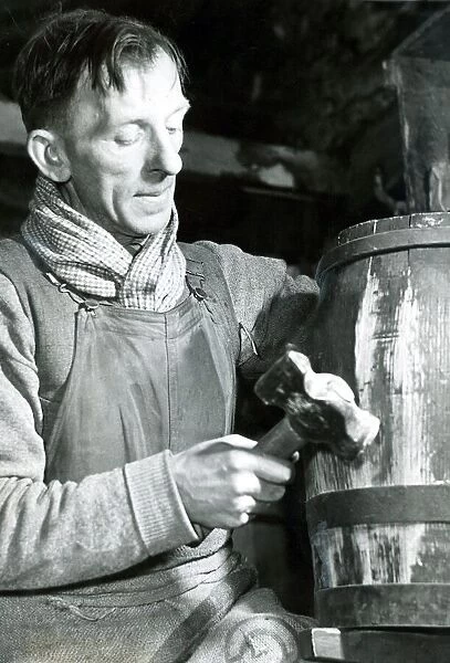 Mr. John parker, a cooper for 30 years, at work on a rum cask bound for one of Her