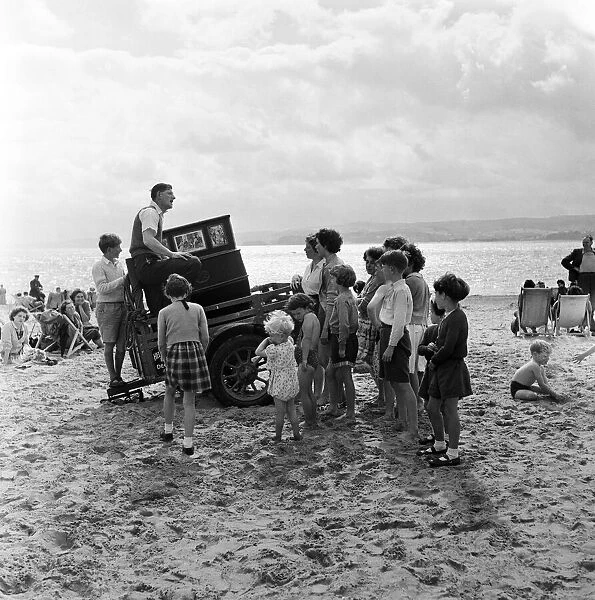 Mr Percy Tucker playing an ancient Barrel Organ on the beach of Exmouth