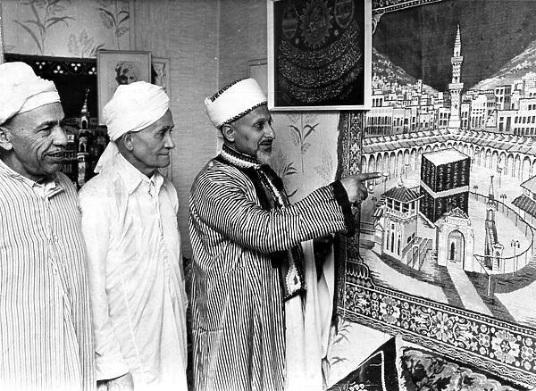 Mr Saleh Hassen of Loudon Square showing a tapestry of Kaaba Mecca to two members of