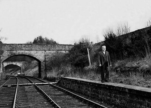 Mr. W. Armstrong (Stationmaster) walks along the platform at the disused Langley Railway