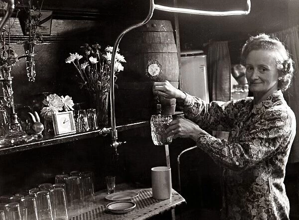 Mrs Allen pours a pint from the barrell circa 1948