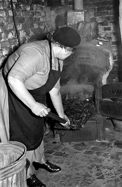Mrs. Ethel Comeny Stoker, seen here feeding the boiler. October 1952 C5925-002