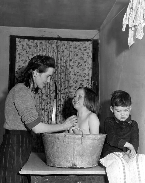 Mrs Florence Kavanagh bathes her daughter Theresa and son Michael