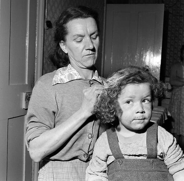 Mrs Gladys Batt attempting to clean her four-year-old daughter Georgina of paint