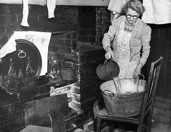 Mrs. L. Wilkinson prepares the bath for her miner sons at hartford Village