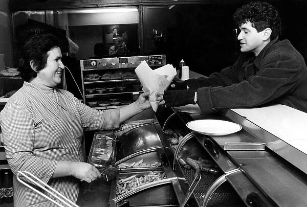 Mrs Maria Stavri serves a customer in a Cardiff fish and chip shop. March 1984