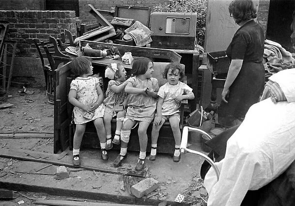 Mrs Rayner and children surrounded by bomb damage on St Marys Road