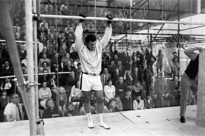 Framed Print : Muhammad Ali in a cage protected by glass from hundreds of fans who paid 50p to watch him