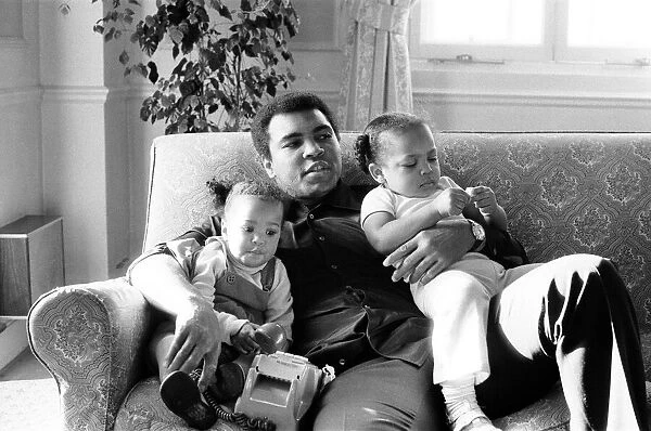 Muhammad Ali cuddling and kissing his daughters Laila, (left )and Hana (right