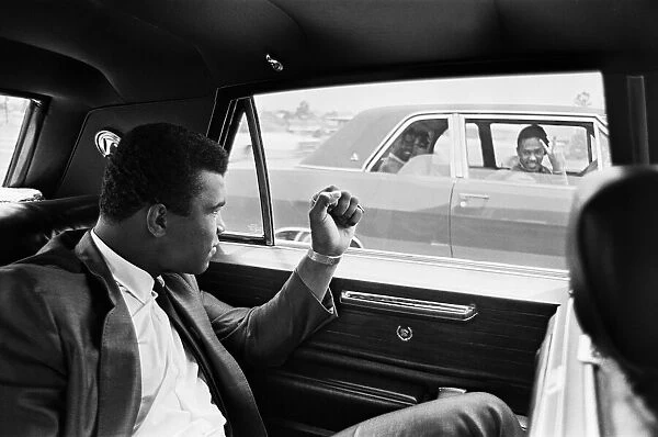 Muhammad Ali gestures to a driver in another car. 31st August 1967