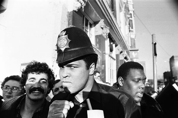 Muhammad Ali seen here on a visit to the UK poses wearing a policemans helmet