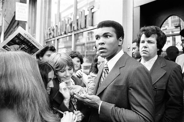 Muhammad Ali signing autographs ahead of his rematch with Joe Frazier. January 1974