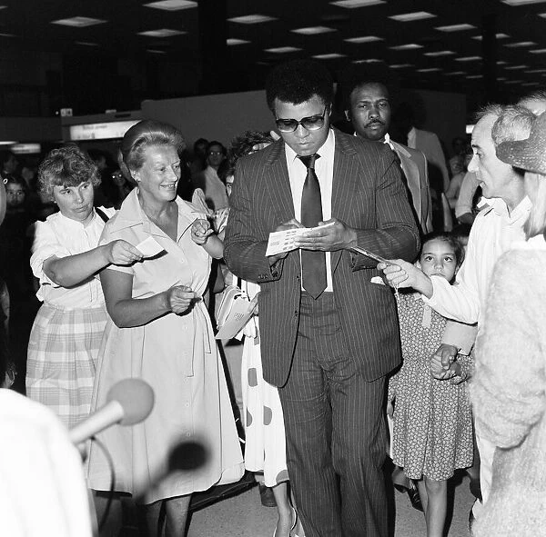 Muhammad Ali signing autographs for fans in England before his journey back to Chicago