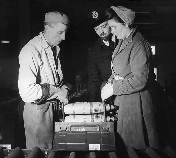 Munition workers Katherine Pearson and Alf Thatcher box up 25 pounder shells at a