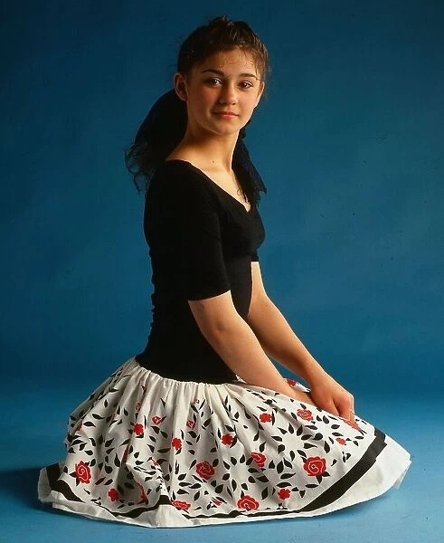 Natalie Robb actress April 1988 sitting on floor wearing black top and white floral skirt