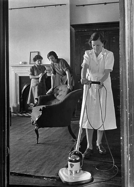 The National Institute of Houseworkers. Electric floor polisher being demonstrated