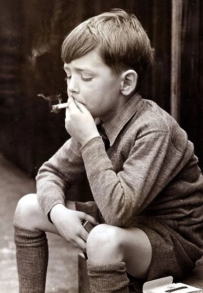 Naughty boy smoking a cigarette, circa 1950