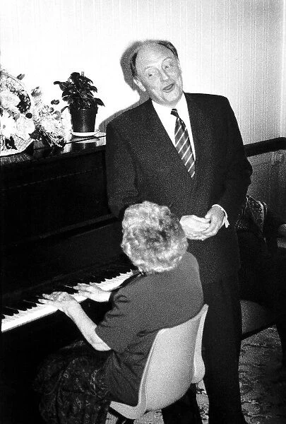 Neil Kinnock MP Former Labour Party Leader with Mrs Ethel Moore on piano during a visit
