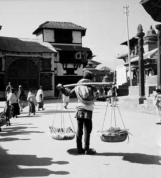 A Nepalese market trader seen here carrying his onions to market in Durbar Square