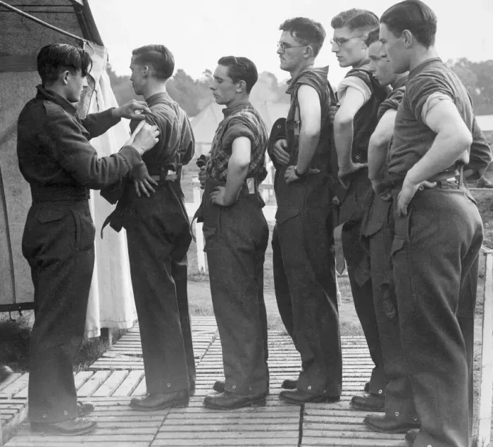 Framed Print : New army recruits wait in line with their sleeves rolled up as they wait to be vaccinated