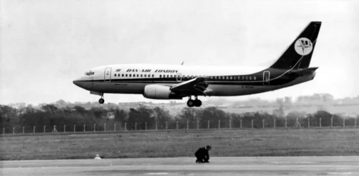 Framed Print : A new Dan-Air Boeing 737 lands at Newcastle Airport as a workman works on an adjoining Framed Print : A new Dan-Air Boeing 737 lands at Newcastle Airport as a workman works on an adjoining