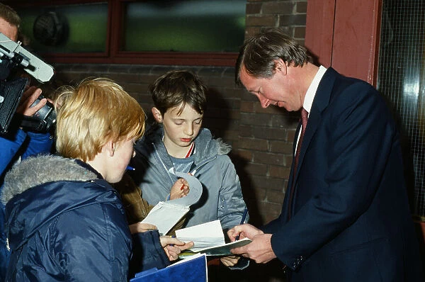 New Manchester United manager Alex Ferguson signs autographs for young fans after taking