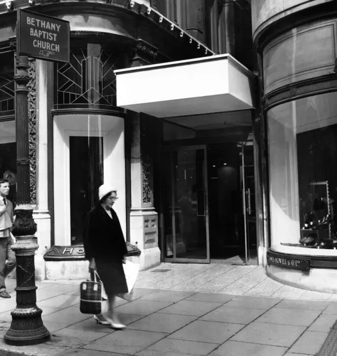 Framed Print : The new and old. Outside the entrance to the department store still stands the sign