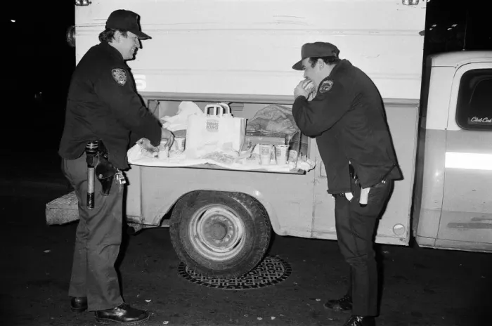 Framed Print : New York Police enjoying a Burger King meal from the side of a van. 13th February 1981