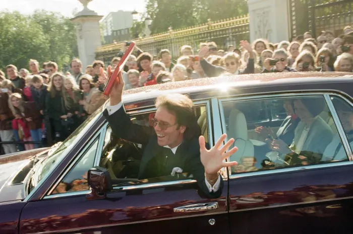 Framed Print : A newly-knighted Sir Cliff Richard leaves Buckingham Palace waving his gong aloft