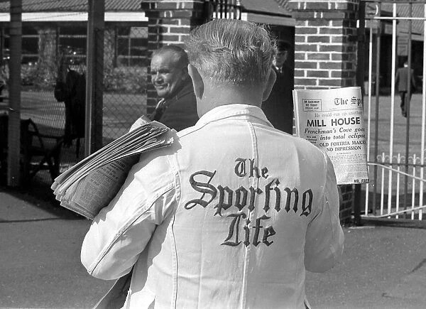A newspaper vendor selling copies of the Sporting Life before a race March 1963