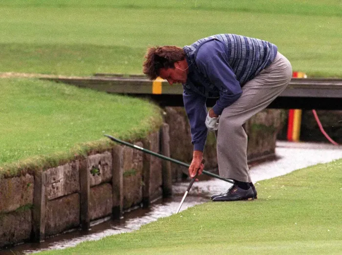 Framed Print : Nick Faldo retrieves his ball from the Swilken burn at the 1st after putting his ball in Framed Print : Nick Faldo retrieves his ball from the Swilken burn at the 1st after putting his ball in