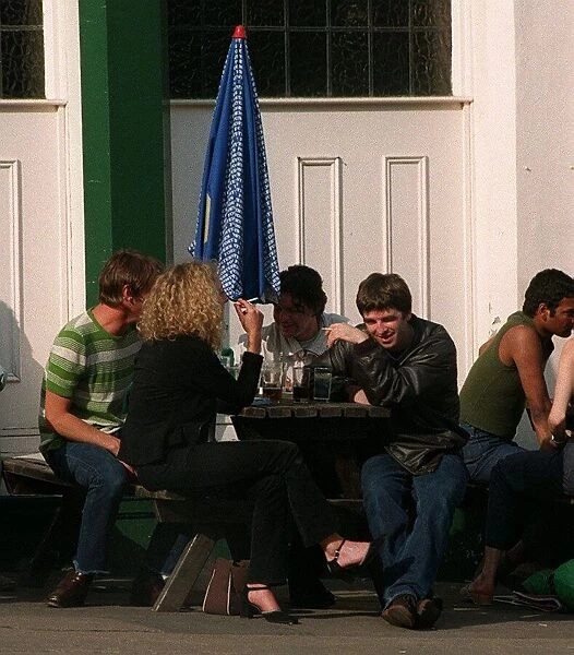 noel gallagher of Oasis sits outside the load of hay pub with mystery blonde
