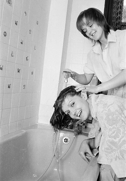The Nolan sisters at home in Ilford. Bernadette helps Linda to wash her hair