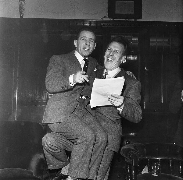Norman Wisdom sits on Bruce Forsyths knee and looks at the script for a pantomime
