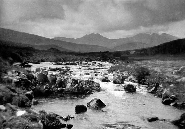North Wales a turbulent stream races towards the sea with Snowdon dominating