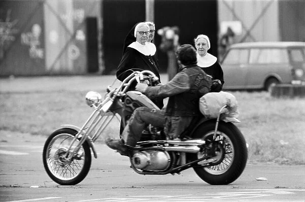 Nuns looking at a man on a motorbike, Watchfield Pop festival