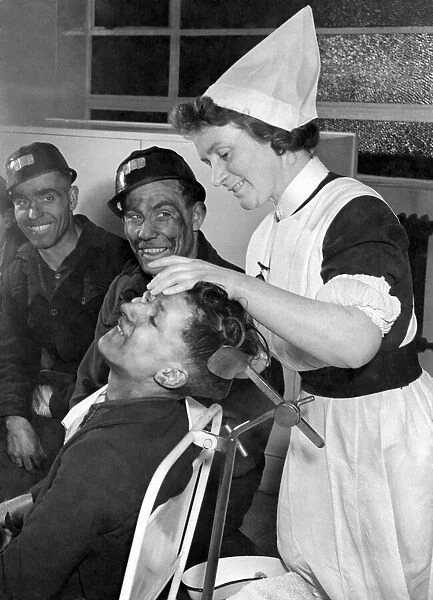 Nurse helps miners beat their target. Miners queue up in the pithead surgery as Sister