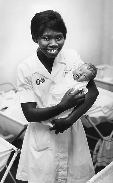 Nurse with a newborn baby at a hospital in Cambridge. Circa 1964