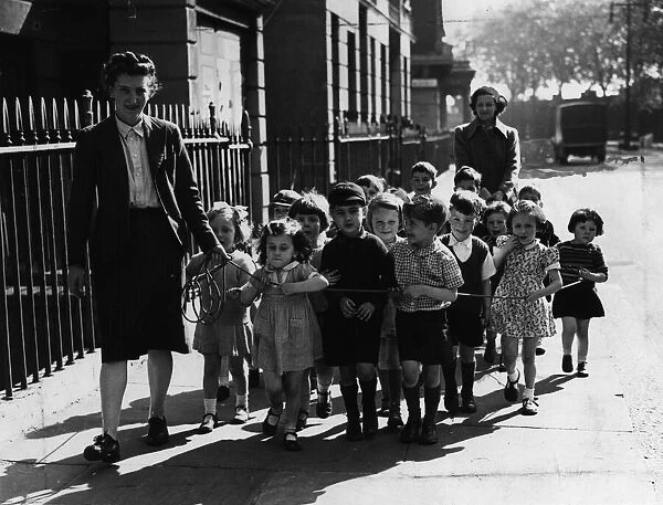 A nurse of Pimlico Day nursery takes the children out for a walk